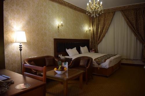 a hotel room with a bed and a table and chairs at Canary Beach Hotel in Yanbu