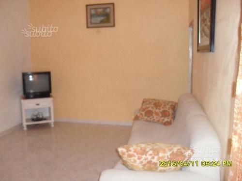 een woonkamer met een bank en een tv bij appartamento centro storico in Castelvetrano Selinunte