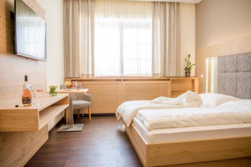 a bedroom with two beds and a desk and a window at Weingut Breitenfelder in Retz