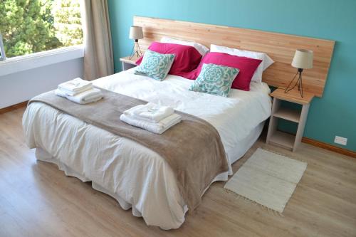 a bedroom with a large bed with towels on it at Nothofagus Apartments in San Carlos de Bariloche