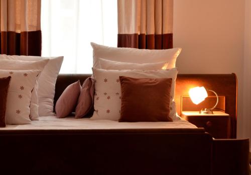 a bed with pillows and a light on a table at Castle View Boutique Apartment in Kraków