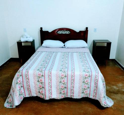 sypialnia z łóżkiem z kocem i 2 szafkami nocnymi w obiekcie Praia do Jatobá w mieście São Jorge