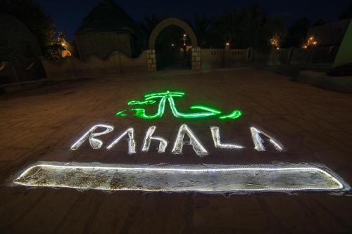 a sign that says raahl with lights on the ground at Rahala Safari Hotel in Qasr Al Farafirah