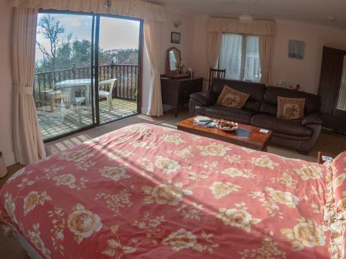 a living room with a bed and a view of a deck at Skerries B and B in Lyme Regis