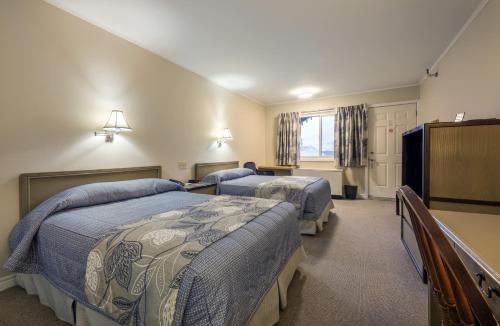 a bedroom with two beds and a television in it at Chebucto Inn in Halifax