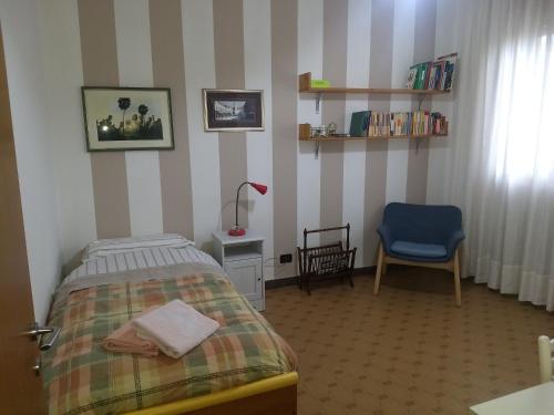 a bedroom with a bed and a chair and a window at B&B Da Franco in Dosson
