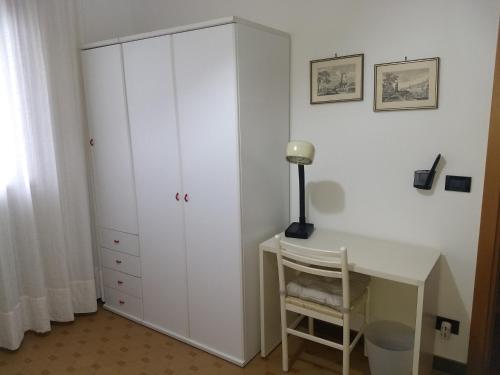 a bedroom with a white cabinet and a desk at B&B Da Franco in Dosson