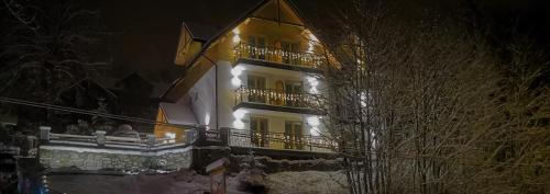 a large yellow building with lights on it at night at Kasiablanka in Szczawnica