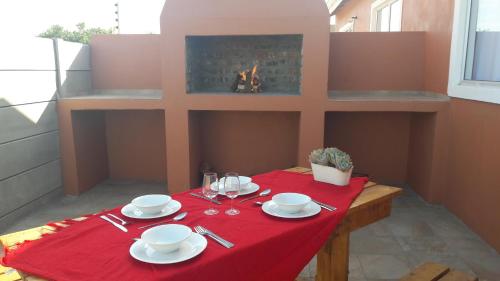 a table with a red table cloth and a fireplace at Little Sister's in Colchester