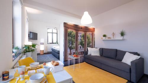 ein Wohnzimmer mit einem Sofa und einem Tisch in der Unterkunft Relax Aachener Boardinghouse Phase 2 in Aachen