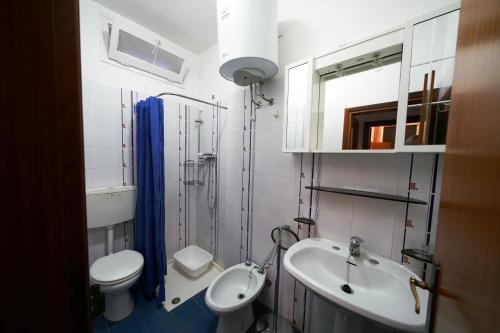 a bathroom with a sink and a toilet and a mirror at Villetta LINDA 10 in Lido delle Nazioni