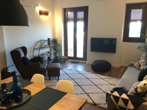 een woonkamer met een tafel en een televisie bij Lovely Apartments at Roman Circus in Tarragona