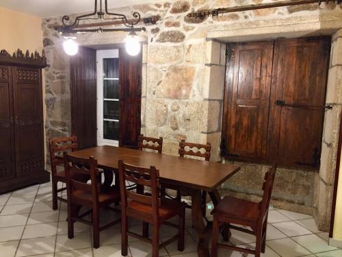 a dining room with a wooden table and chairs at Casa Vilar in Sanxenxo
