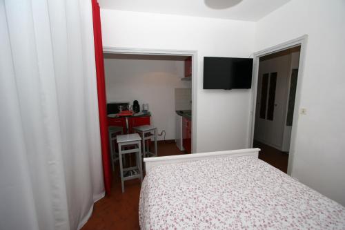 małą sypialnię z łóżkiem i kuchnią w obiekcie Studio Le Virgile - Annecy w Annecy