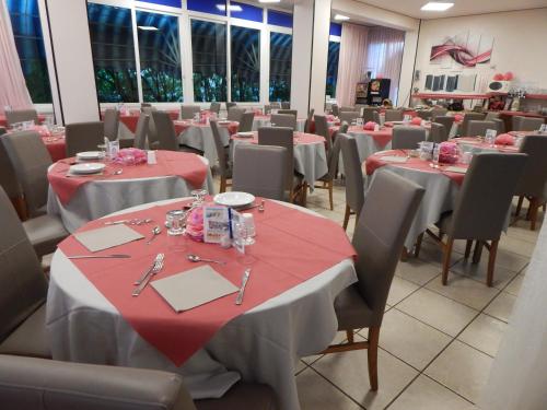 uma sala de jantar com mesas e cadeiras vermelhas e brancas em Hotel Vera em Riccione