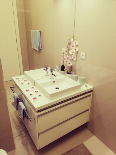 a bathroom with a white sink and a mirror at Mar Beach Apartment in Póvoa de Varzim