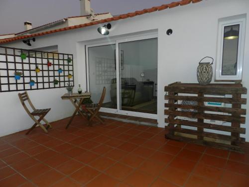 a living room with a table and chairs and a window at Casas do Ardila in Santo Amador
