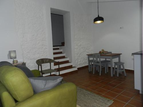 a living room with a green couch and a table at Casas do Ardila in Santo Amador