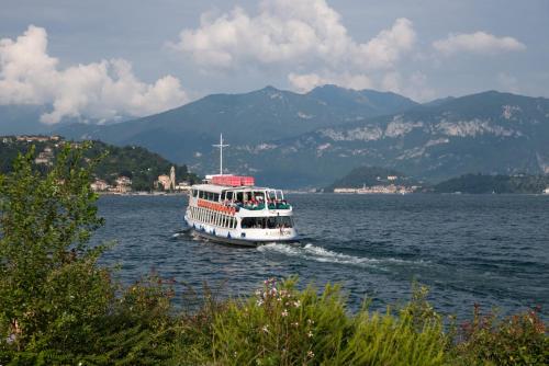 a boat on the water with mountains in the background at Mansarda I Cipressi in Lenno