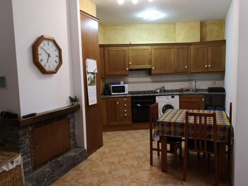 Apartament de la Lali Roní في Roní: مطبخ مع طاولة وساعة على الحائط