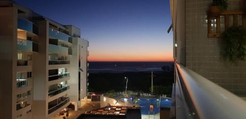 a view from the balcony of a building at sunset at Praia Grande Arraial do Cabo in Arraial do Cabo