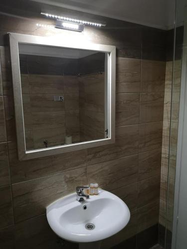 a bathroom with a white sink and a mirror at Mediterranean Blue in Kavos