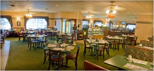 a restaurant with tables and chairs in a room at Bay Motel in Green Bay