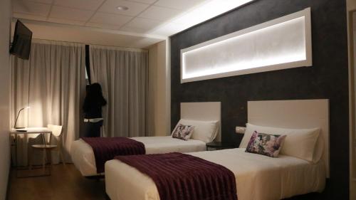 Hotel Malecon tesisinde bir odada yatak veya yataklar