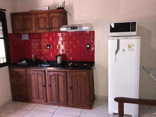 a kitchen with a stove and a refrigerator at Departamentos El Chileno in Puerto Iguazú