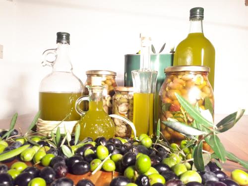 a bunch of olives and bottles of wine on a table at Agriturismo La Talpa in Marsiliana