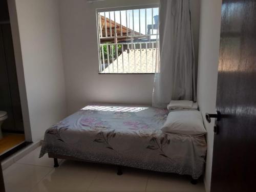 un piccolo letto in una camera con finestra di Propriedade Silva a Gamboa