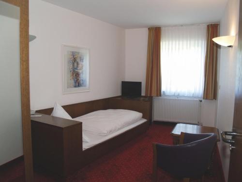 a bedroom with a bed and a desk and a window at Hotel Felsenkeller in Rüdesheim am Rhein
