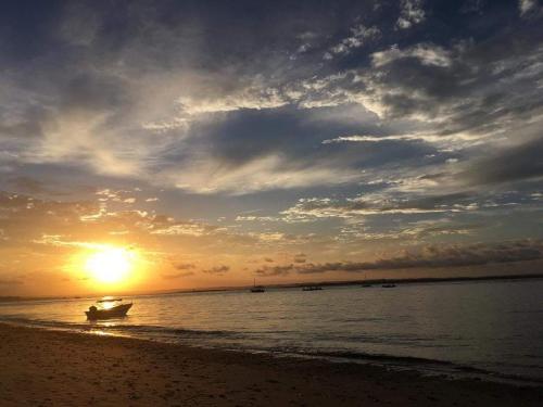 a boat on the beach with the sun setting at Propriedade Silva in Gamboa