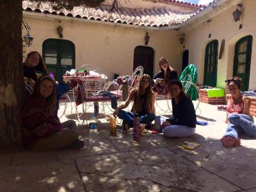 a group of people sitting on the ground in front of a house at Casa de Huéspedes María Victoria in Potosí