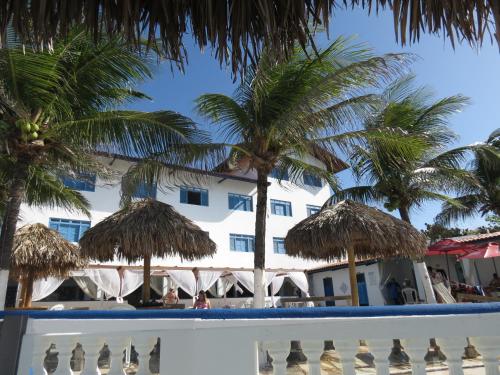 a view of a hotel from the beach with palm trees at La Suite Praia Hotel in Caucaia