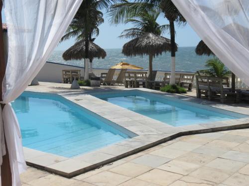 a swimming pool with a view of the ocean at La Suite Praia Hotel in Caucaia