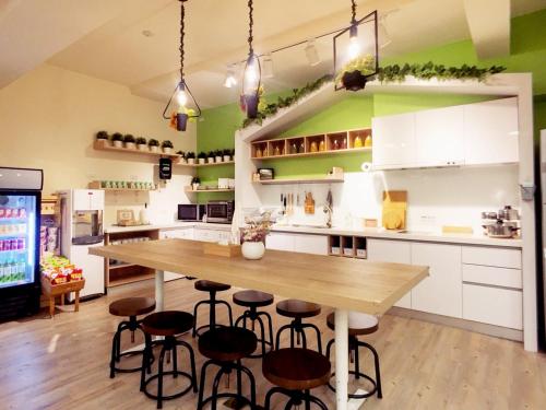 a kitchen with a large wooden table and stools at Green Hotel - Fengjia in Taichung