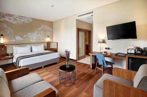 丹格朗的住宿－Swiss-Belhotel Airport Jakarta，配有一张床和一张书桌的酒店客房