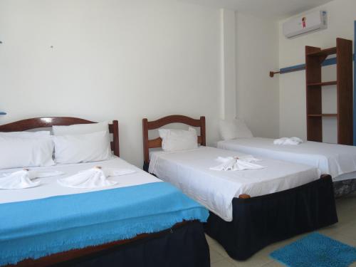 two beds in a room with white and blue at La Suite Praia Hotel in Caucaia