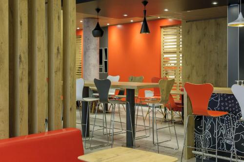 a dining room with orange walls and a table and chairs at ibis Berlin Kurfuerstendamm - neu renoviert in Berlin