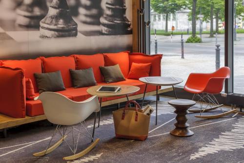 an orange couch in a store with chairs and a table at ibis Berlin Kurfuerstendamm - neu renoviert in Berlin