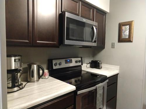 a kitchen with a stove and a microwave at Exclusive Townhome - Central Raleigh Location in Raleigh
