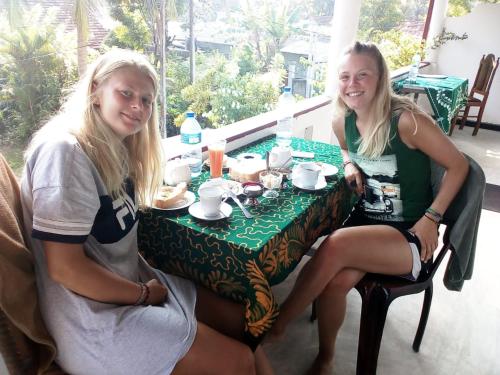 Dos chicas sentadas en una mesa con comida. en Rest Point, en Unawatuna