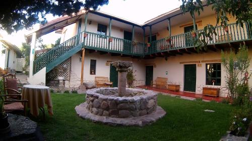 a building with a fountain in the yard of a house at Hospedaje La Florida in Urubamba