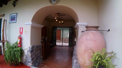 a hallway with a large vase in front of a door at Hospedaje La Florida in Urubamba