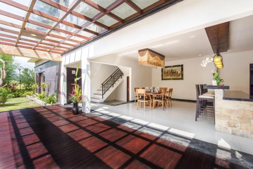 an open living room and dining room with a glass ceiling at Villa Cendrawasih Ubud in Tegalalang