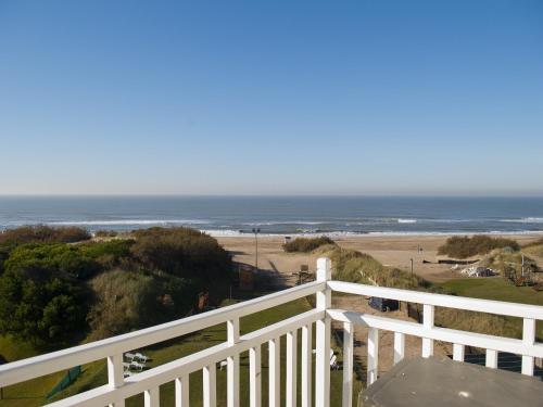 a view of the beach from the balcony of a house at Costa Carilo Apart de Mar By HS in Carilo