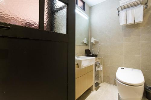 a bathroom with a toilet and a sink at Vella Suite Hotel in Suwon