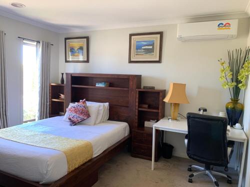 a bedroom with a bed and a desk and a chair at Apple House in Tarneit