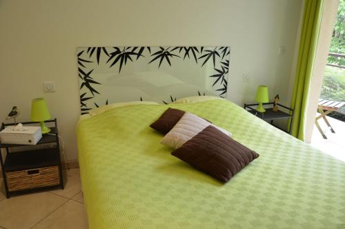 a green bed with two pillows on top of it at La Villa Antalya in Ault